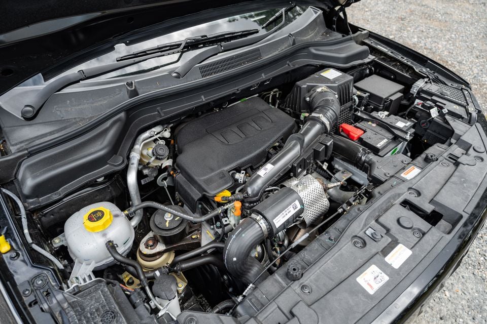 Engine bay of a Mahindra XUV 3XO with the bonnet open, showing the turbocharged petrol engine, air intake, battery, and coolant reservoir