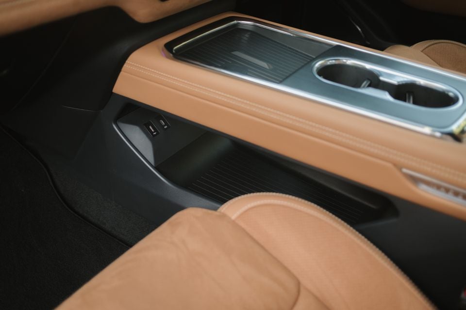 Close-up of the centre console storage compartment with USB ports and cupholders in a 2027 Mazda 6e Atenza