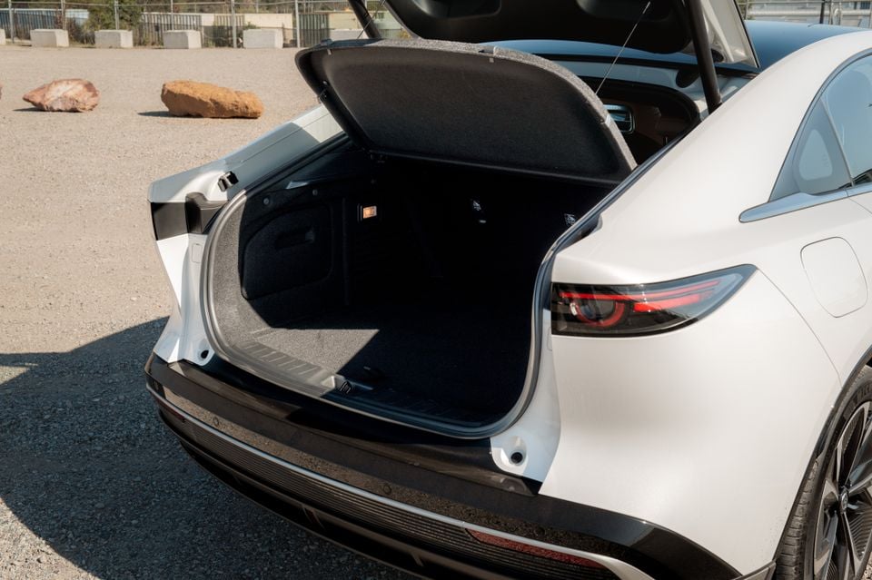 The open boot of a white 2027 Mazda 6e Atenza sedan, showing the empty cargo area.