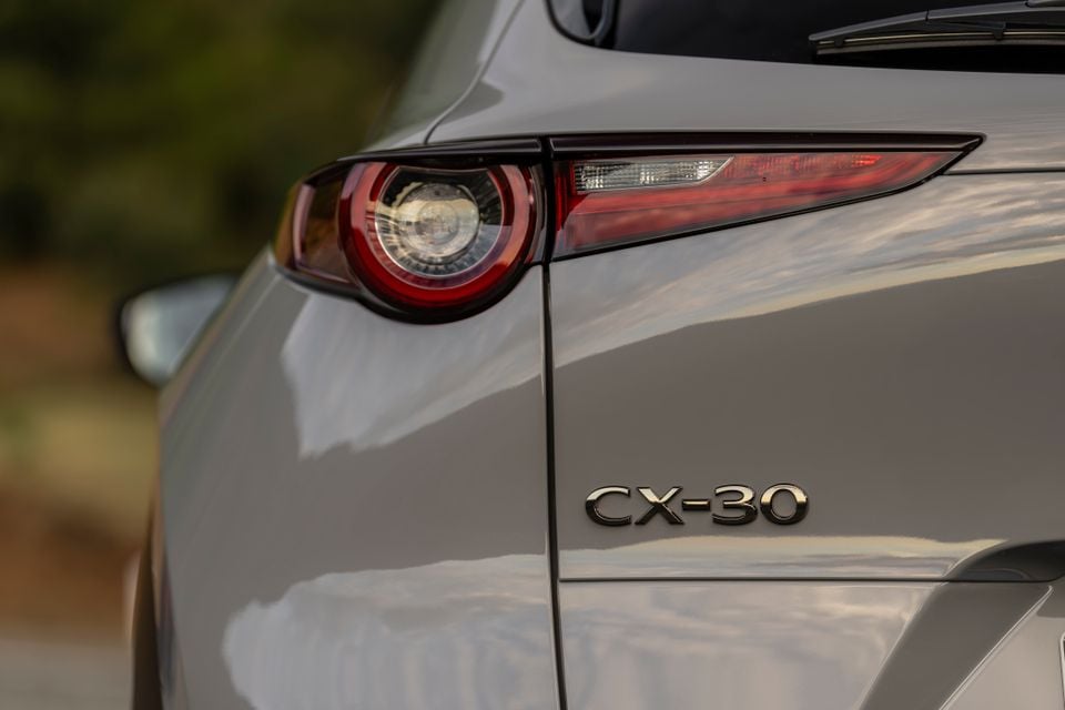 Close-up of the left tail-light and CX-30 badge on the tailgate of a grey 2027 Mazda CX-30 SUV