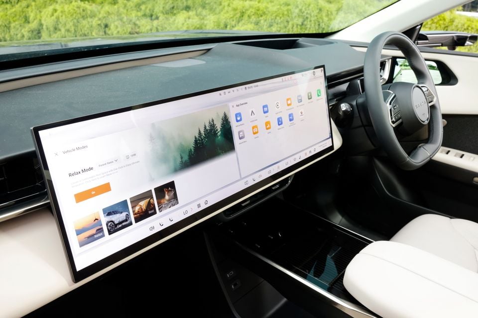 The large central touchscreen of a 2027 Mazda CX-6e shows the vehicle modes menu with a steering wheel visible to the right.
