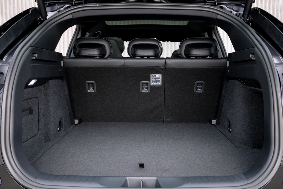 The empty boot of a 2027 Mazda CX-6e SUV, shown with the rear seats up and cargo area visible.