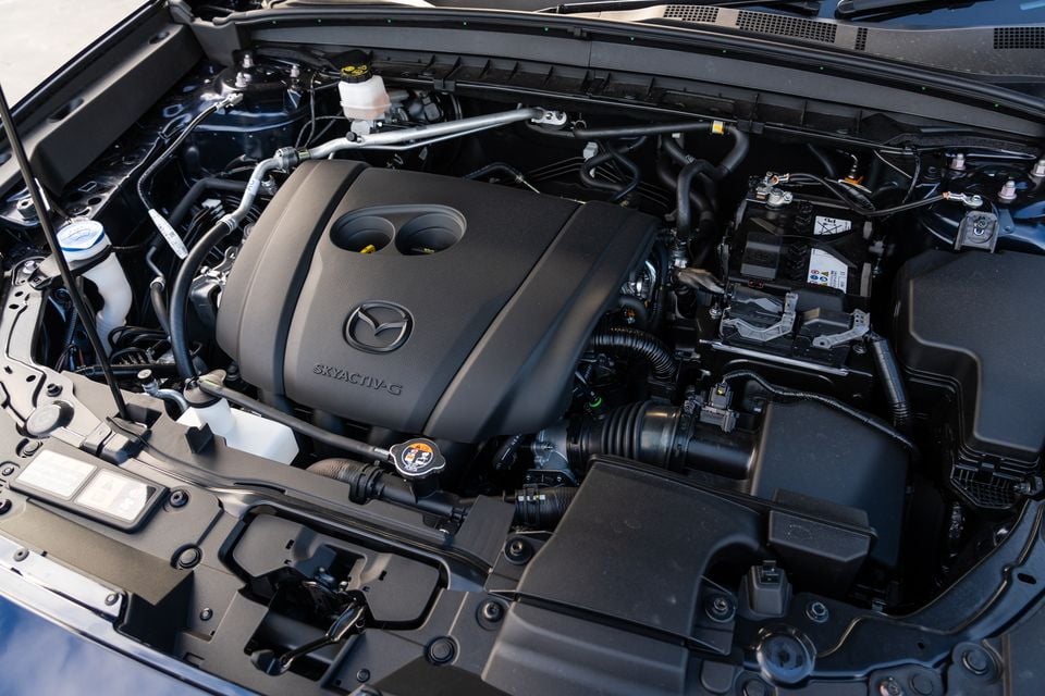 Mazda Skyactiv-G engine bay with the bonnet open, showing the engine cover and surrounding components