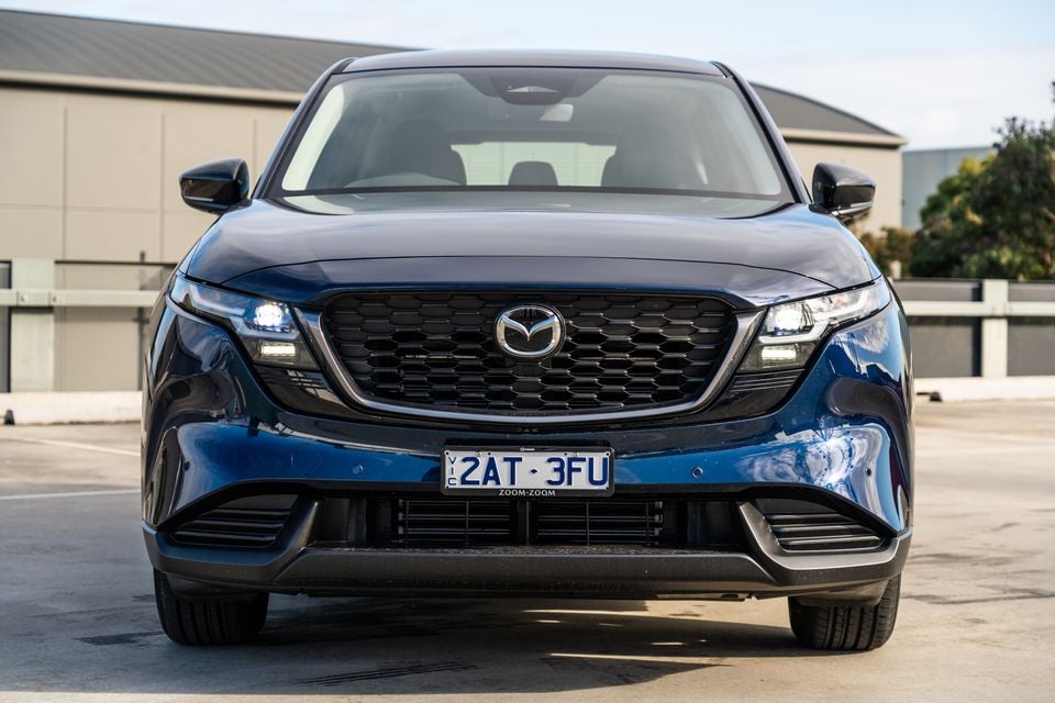 Front view of a dark blue Mazda CX-5 SUV parked in a car park, showing the grille, headlights and Victorian number plate