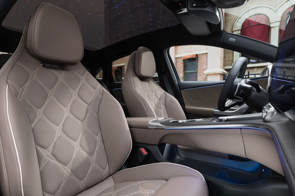 Front seats of the 2027 Mercedes-Benz C-Class Electric with quilted beige leather, steering wheel, centre console and illuminated star-pattern glass roof
