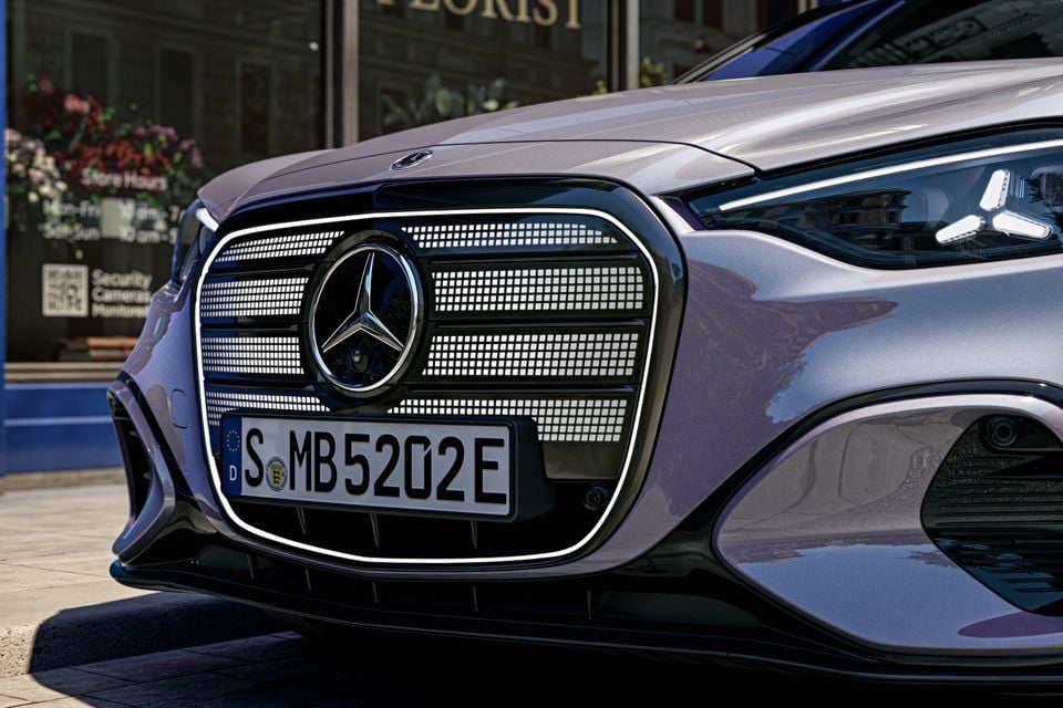 Close-up of the illuminated star-pattern grille and Mercedes-Benz badge on a silver-lilac 2027 Mercedes-Benz C-Class electric