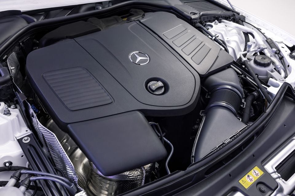 Mercedes-Benz engine bay showing the branded engine cover with the three-pointed star logo, viewed from above with the bonnet open