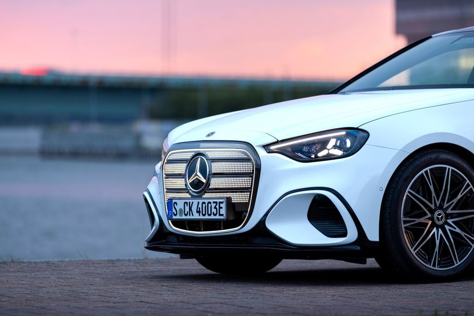 Close-up of the front grille, Mercedes-Benz star badge, and headlight of a white 2027 Mercedes-Benz C-Class electric