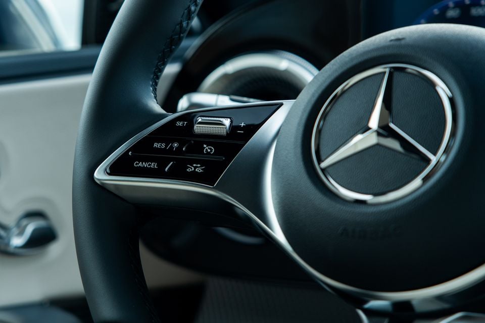 Close-up of the Mercedes-Benz steering wheel in the 2027 C-Class Electric, showing cruise control buttons and the three-pointed star badge