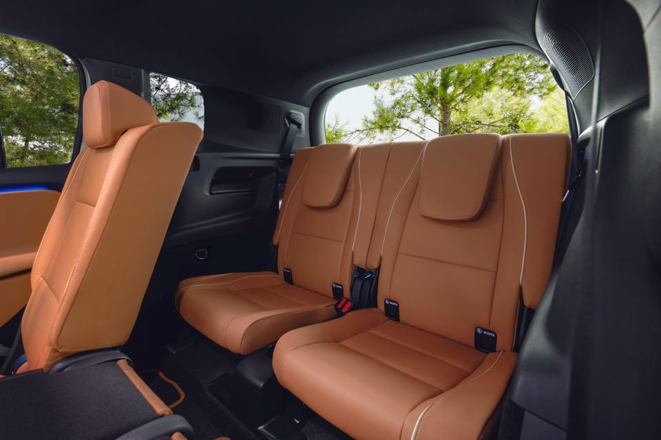 Tan leather rear seats of a 2027 Mercedes-Benz GLB, showing three second-row seats with ISOFIX anchor points and contrast stitching