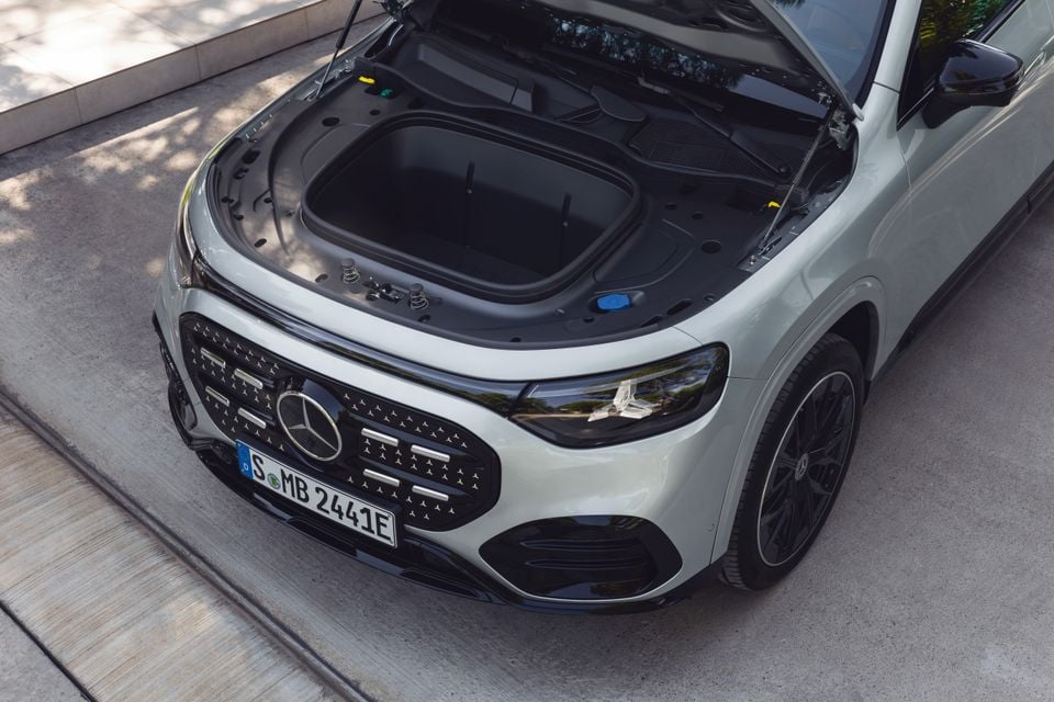A white Mercedes-Benz GLB SUV with its bonnet open, revealing a front storage compartment (frunk), seen from above at the front.