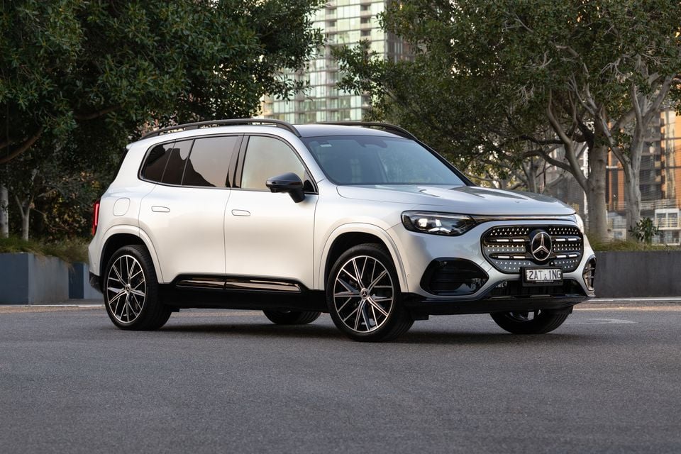 A silver 2027 Mercedes-Benz GLB 350 4Matic electric SUV parked on a city street, seen from the front three-quarter angle
