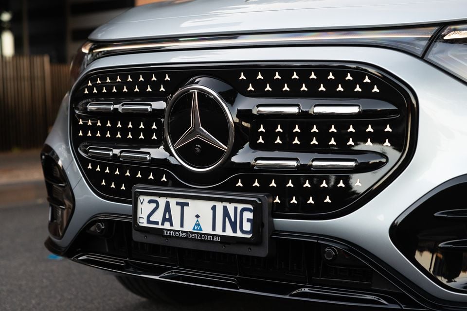 Close-up of the 2027 Mercedes-Benz GLB 350 4Matic electric's black panel grille with star motifs, illuminated three-pointed star badge and EV number plate
