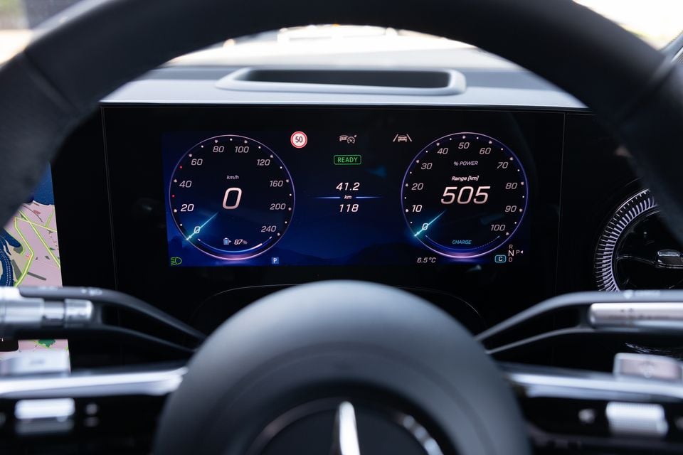 Digital instrument cluster in the 2027 Mercedes-Benz GLB 350 4Matic electric, showing speed, 87% battery and 505km range, seen through the steering wheel