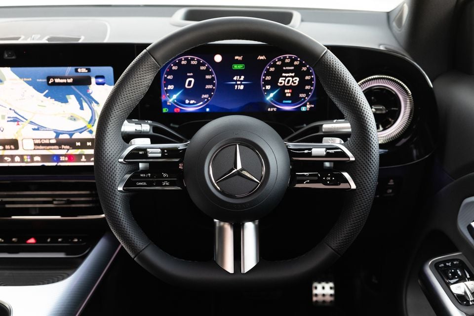 Steering wheel and digital instrument cluster of the 2027 Mercedes-Benz GLB 350 4Matic electric SUV, with a navigation map on the central touchscreen