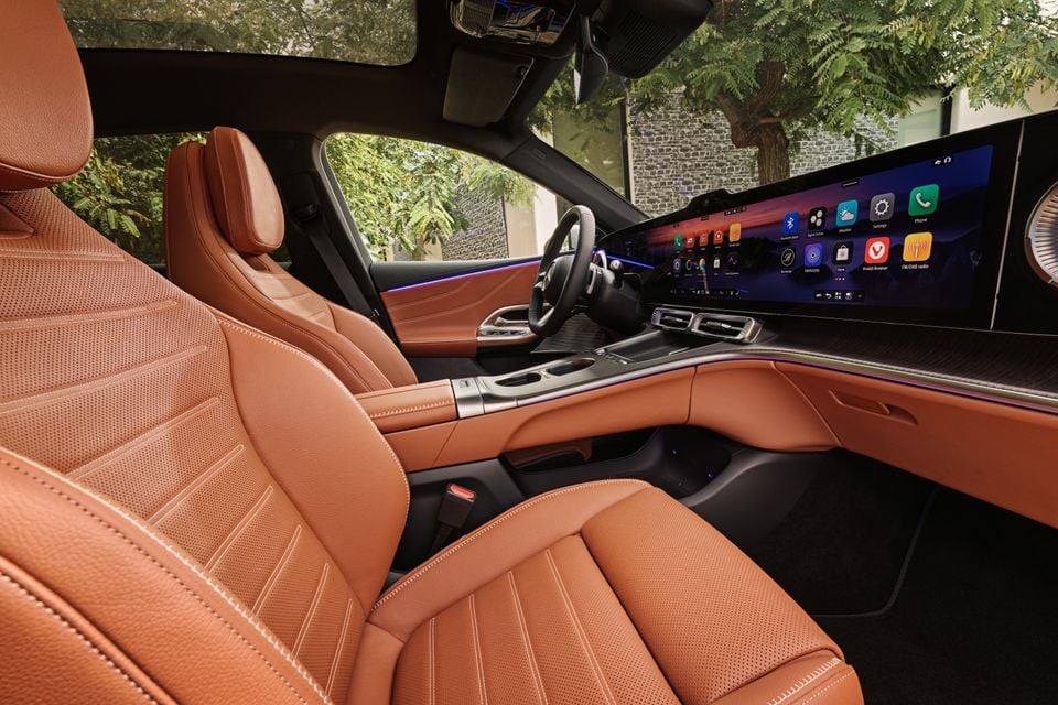 Interior of a Mercedes-Benz GLC 400 Electric showing tan leather seats, a large widescreen infotainment display, and illuminated ambient lighting