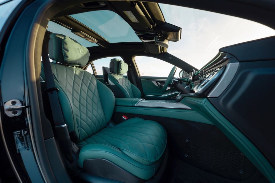 Green leather front seats and dashboard of a 2027 Mercedes-Benz S-Class, viewed from the rear passenger seat