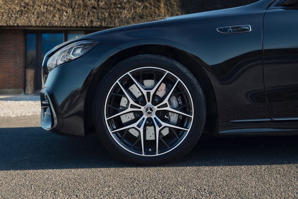 Close-up of the front wheel and alloy rim on a black Mercedes-Benz S-Class sedan parked outdoors.