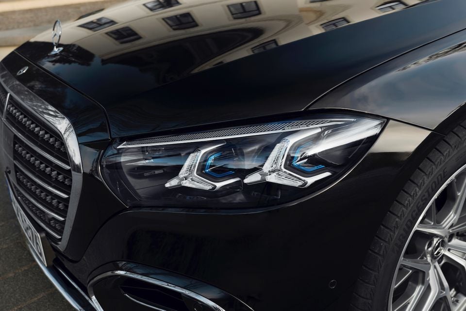 Close-up of the headlight and grille on a black Mercedes-Benz S-Class sedan