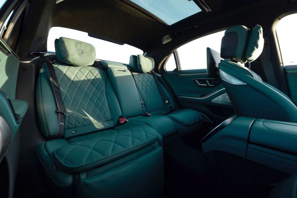 The rear seats of a 2027 Mercedes-Benz S-Class show diamond-quilted teal leather upholstery and a panoramic sunroof.