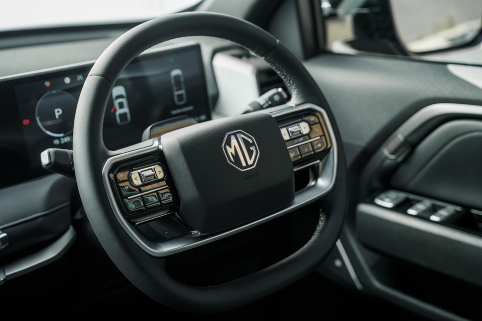 Steering wheel of the 2027 MG U9 EV with MG badge and button controls, digital instrument display showing park mode behind it
