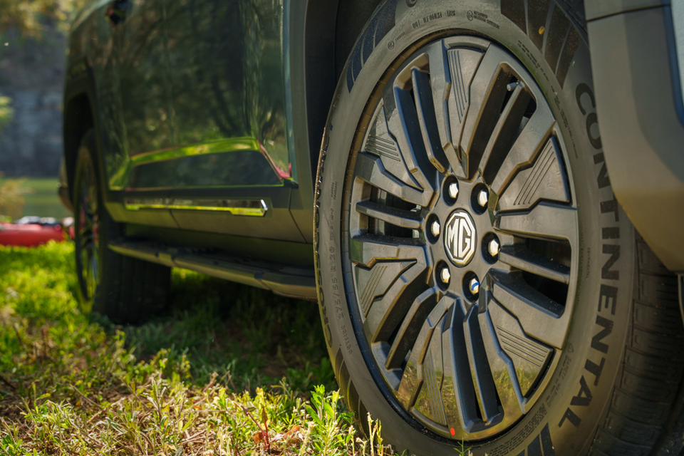 Close-up of the black multi-spoke alloy wheel with MG centre badge and Continental tyre on a 2027 MG U9 ute parked on grass