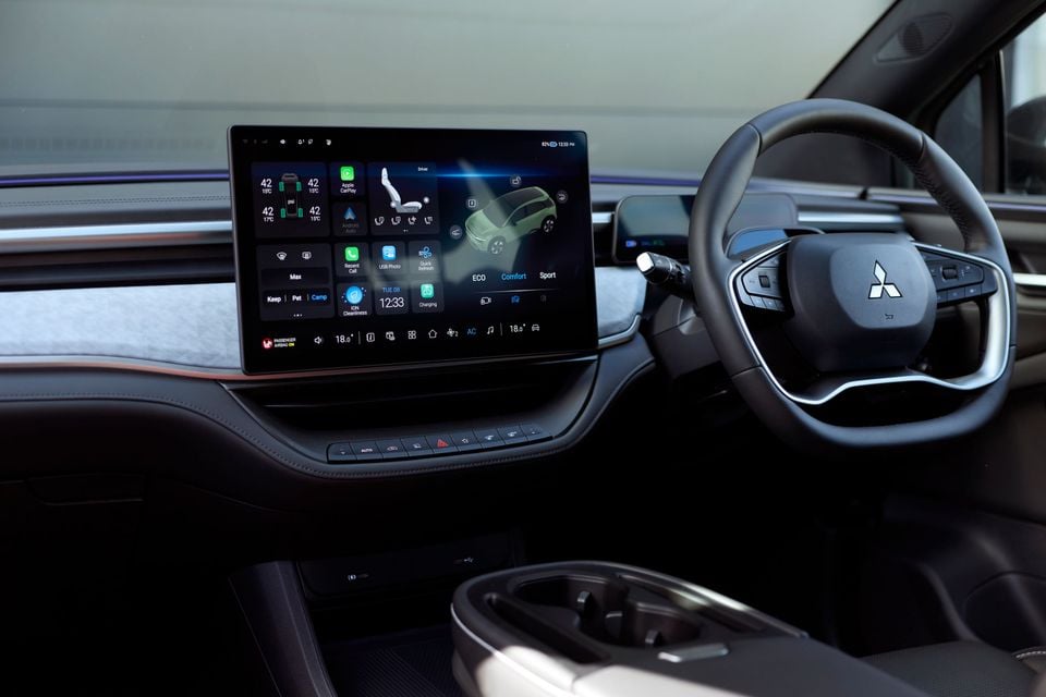 The interior of a 2027 Mitsubishi ASX showing the steering wheel with Mitsubishi badge and a large touchscreen infotainment display