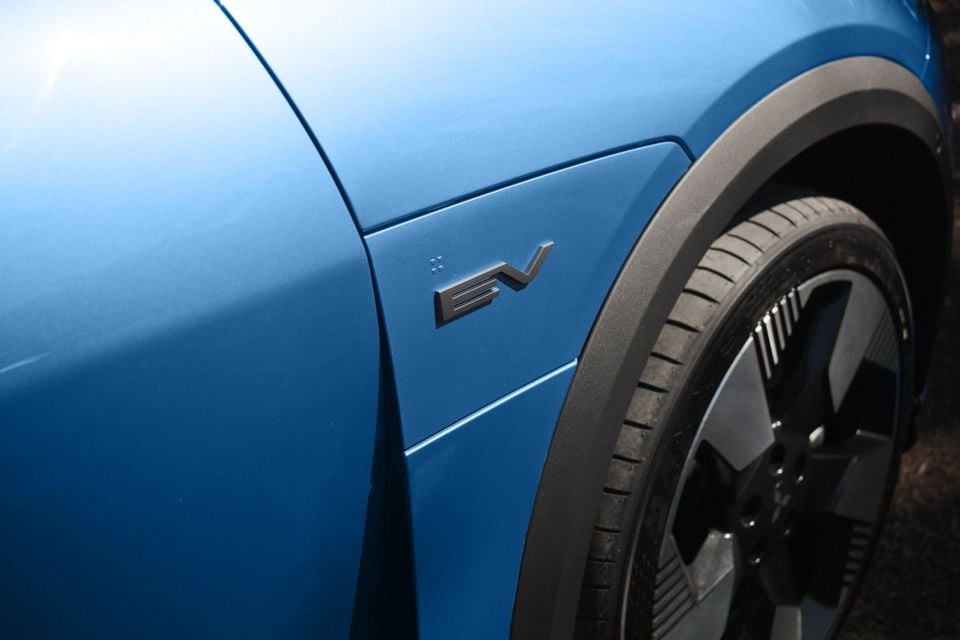 Close-up of the EV badge and front wheel on a blue Mitsubishi ASX electric vehicle