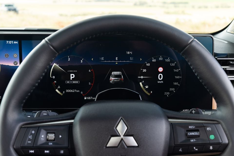Steering wheel and digital instrument cluster of the 2027 Mitsubishi Pajero, showing park mode with 4H and Snow drive settings selected