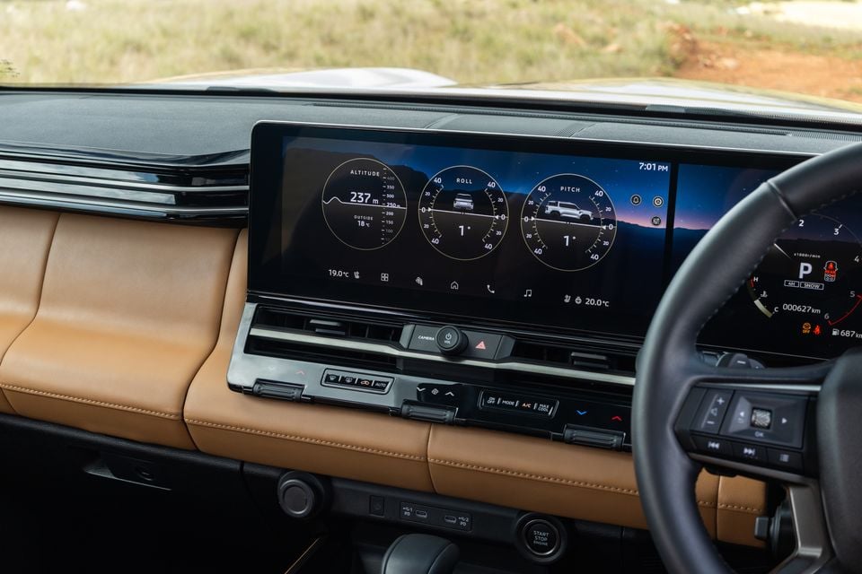 Dashboard of the 2027 Mitsubishi Pajero showing a widescreen display with altitude, roll and pitch off-road gauges beside tan leather trim