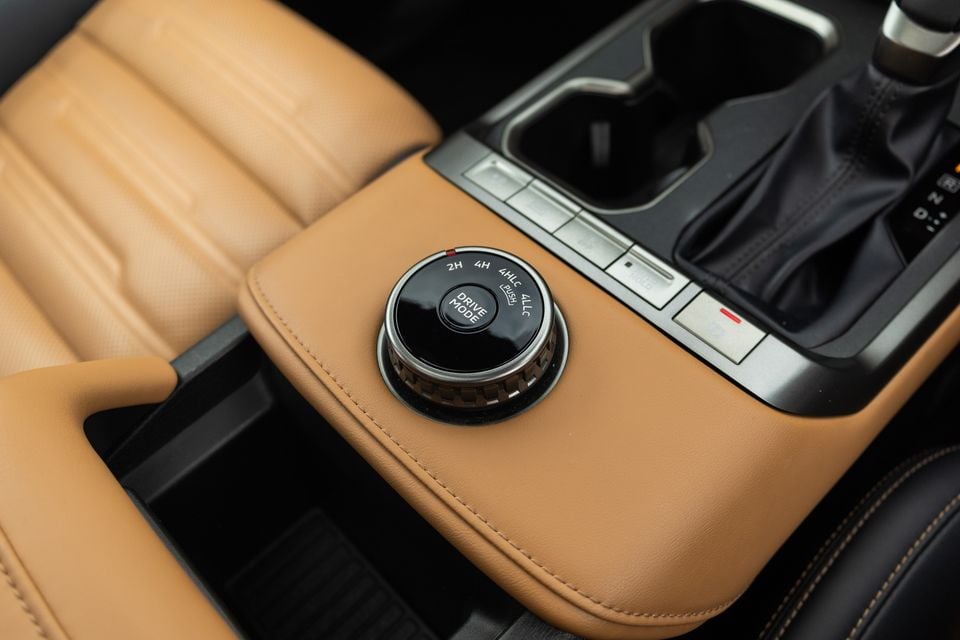 Rotary drive mode selector with 2H, 4H, 4HLC and 4LLC settings on the tan leather centre console of a 2027 Mitsubishi Pajero