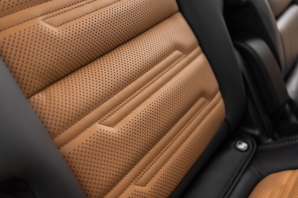 Close-up of perforated tan leather seat upholstery with black bolsters and contrast stitching in the 2027 Mitsubishi Pajero