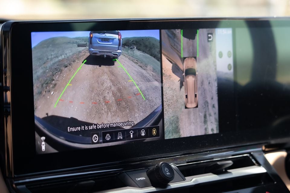Infotainment screen in the 2027 Mitsubishi Pajero showing the reversing camera with guidelines and a bird's-eye surround view while off-road