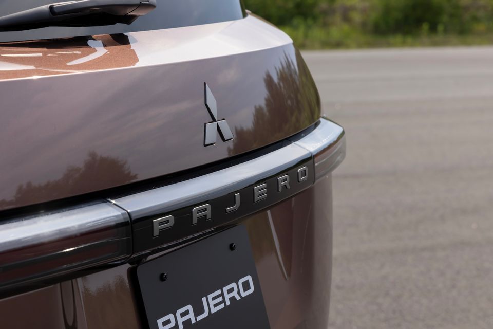 Close-up of the rear badge and Mitsubishi logo on a brown Mitsubishi Pajero SUV