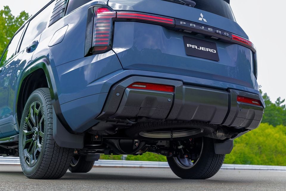 Rear view of a blue Mitsubishi Pajero SUV showing tail lights, rear bumper and underbody detail
