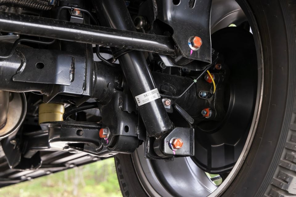 Close-up view of the rear suspension and underbody components of the 2027 Mitsubishi Pajero, showing shock absorbers, control arms, and wheel assembly.