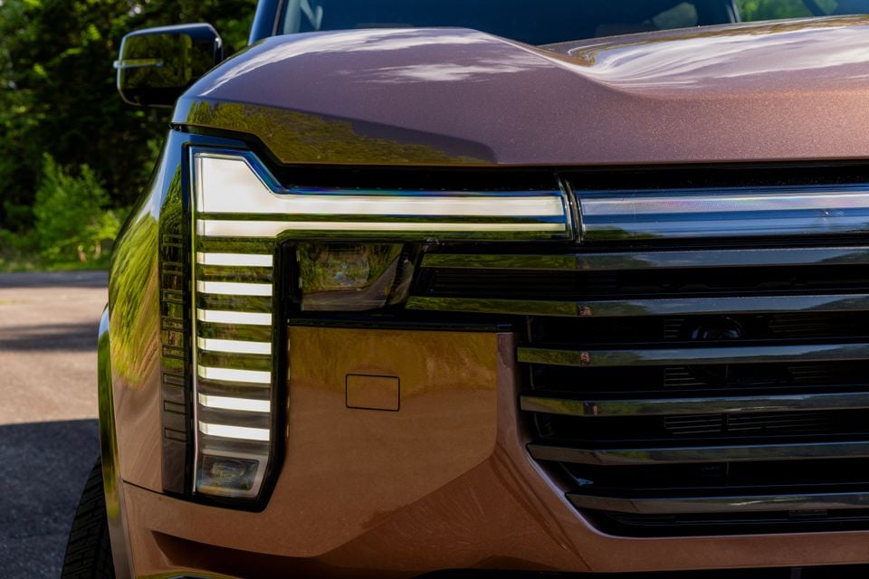 Close-up of the front headlight and grille of a bronze 2027 Mitsubishi Pajero