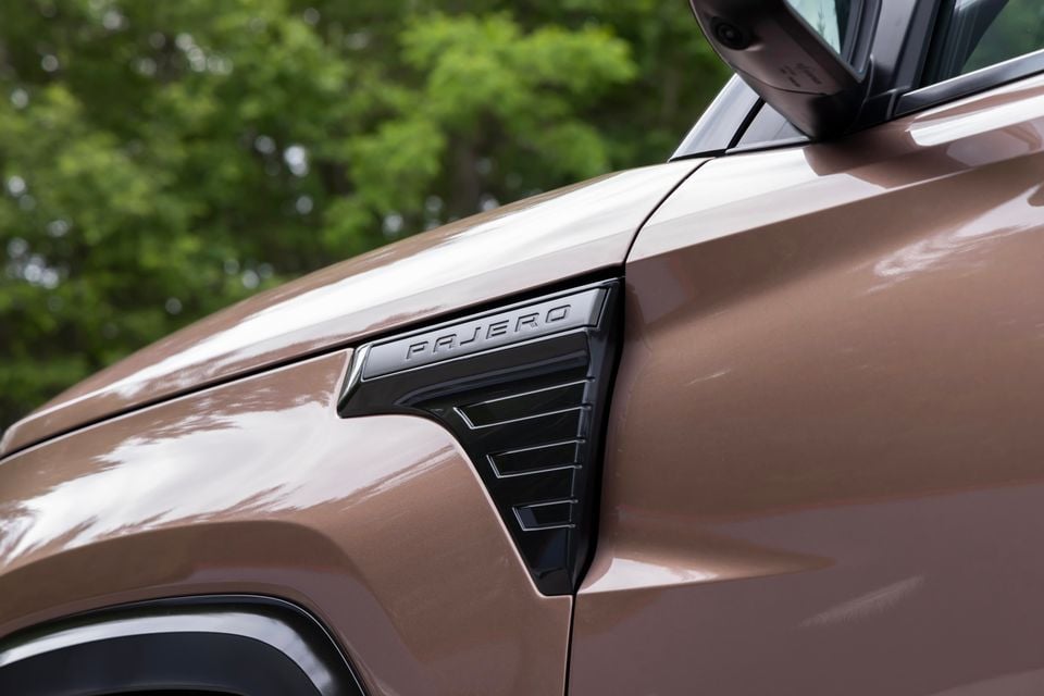 Close-up of the fender vent and Pajero badge on a brown Mitsubishi Pajero SUV