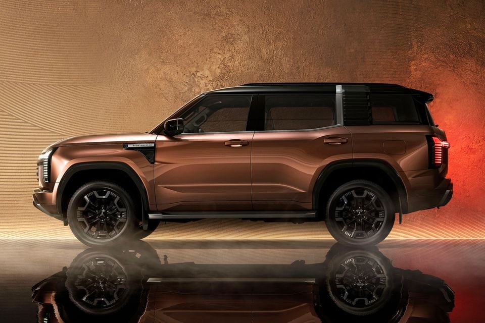 A bronze Mitsubishi Pajero large SUV shown from the side in a studio setting