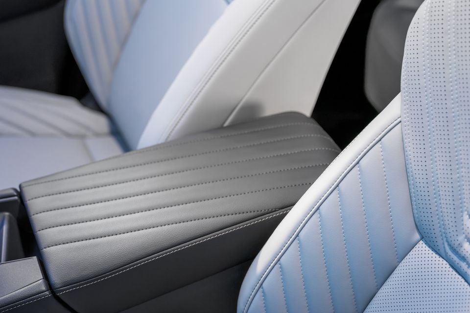 Light blue and grey two-tone leather seats and centre armrest inside a 2027 Nissan Rogue Hybrid