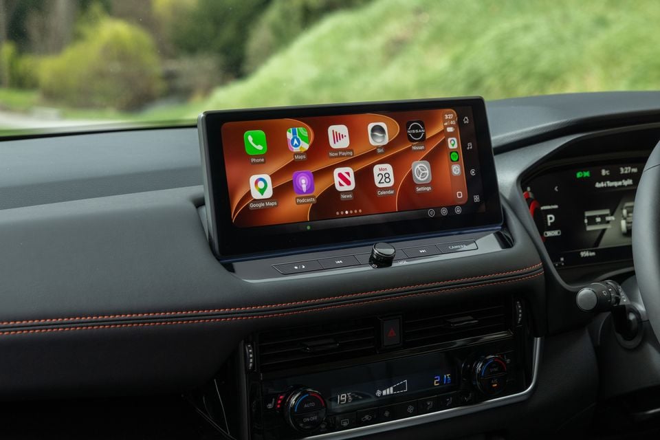 The infotainment touchscreen and climate controls inside a 2027 Nissan X-Trail Rock Creek, showing Apple CarPlay on the display.