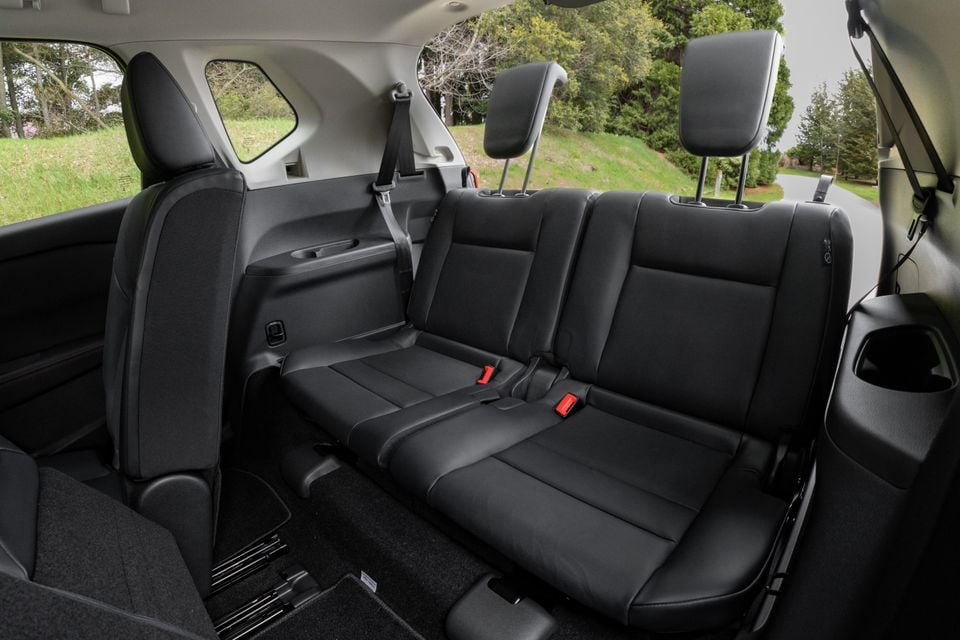 The third-row rear seats of a 2027 Nissan X-Trail Rock Creek, shown with black leather upholstery and a view through the rear windows.