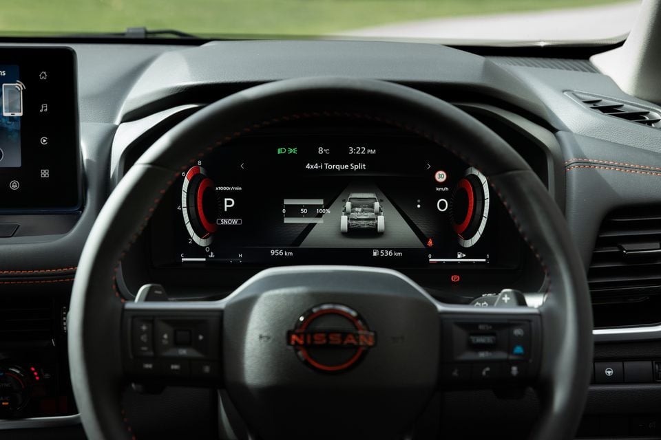 Close-up of the Nissan steering wheel and digital instrument cluster showing the 4x4-i torque split display, in what appears to be a 2027 Nissan X-Trail.