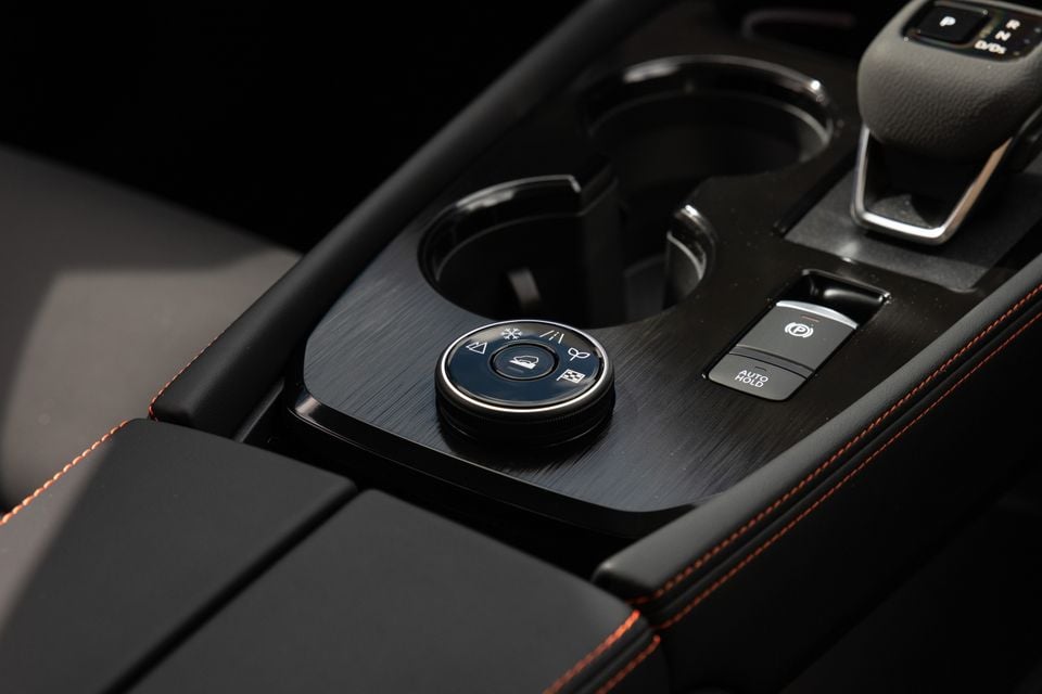 Close-up of the centre console in a 2027 Nissan X-Trail Rock Creek, showing the drive mode dial, auto hold button and electronic parking brake switch.