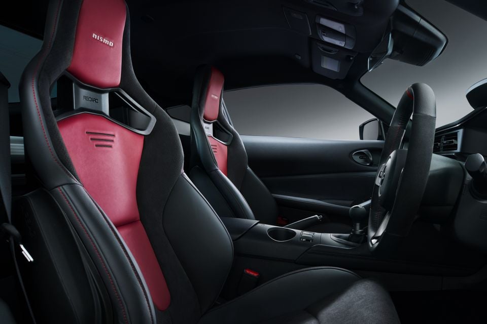 Nissan Z Nismo interior showing red and black Recaro bucket seats, centre console and steering wheel