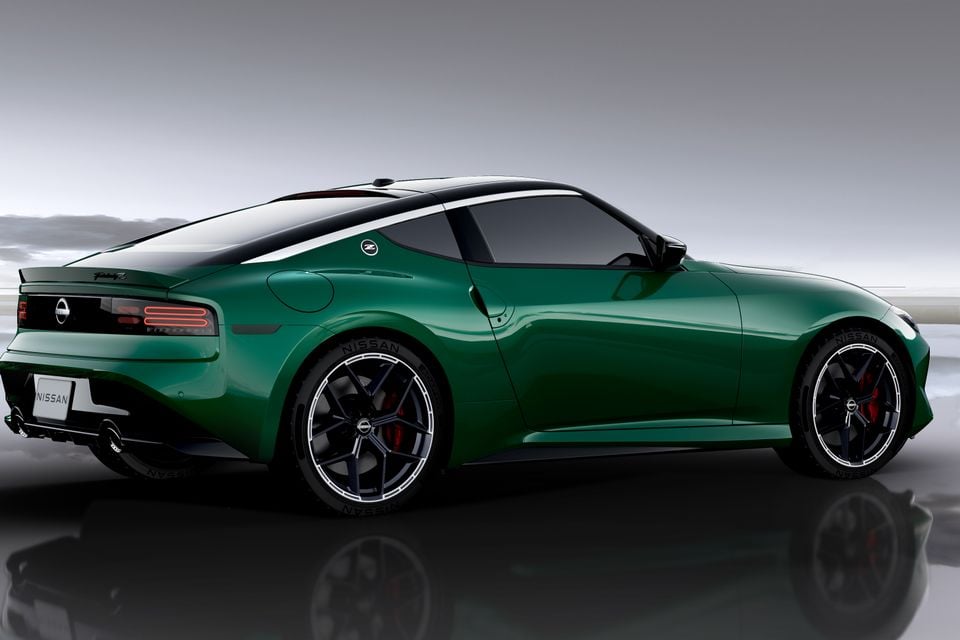 A green Nissan Z coupe seen from the rear three-quarter angle, featuring red brake calipers and dark alloy wheels