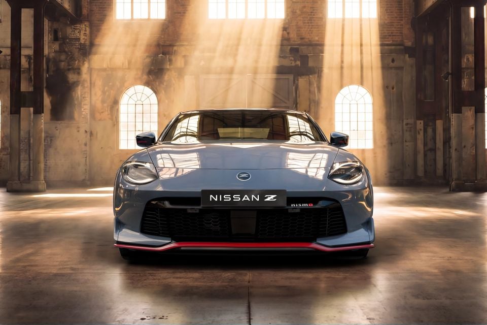 Front view of a grey Nissan Z Nismo sports coupe parked inside a sunlit industrial warehouse