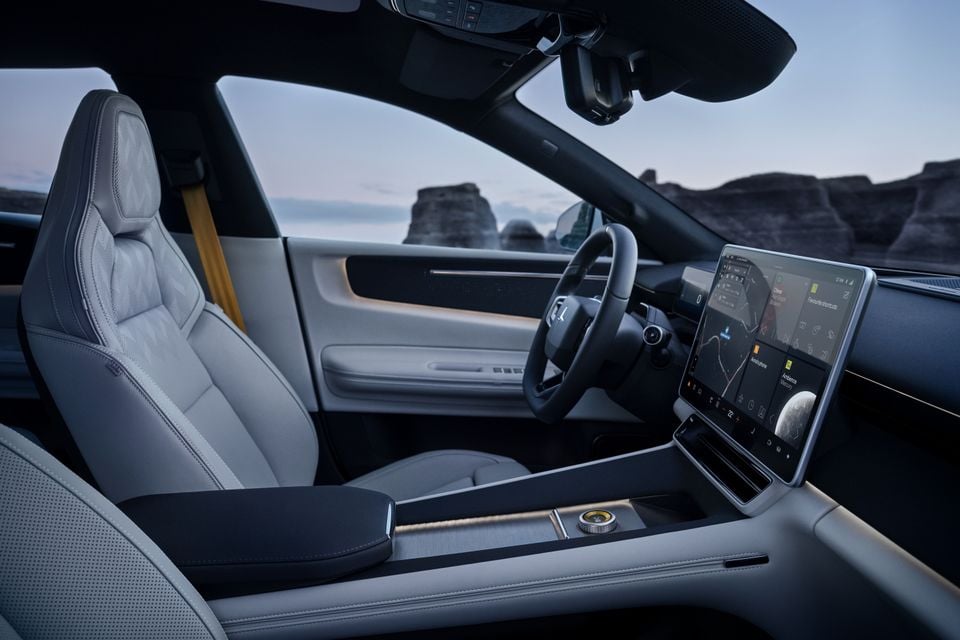 Interior of a 2027 Polestar 4 showing the front seats, centre console, steering wheel, and large touchscreen infotainment display
