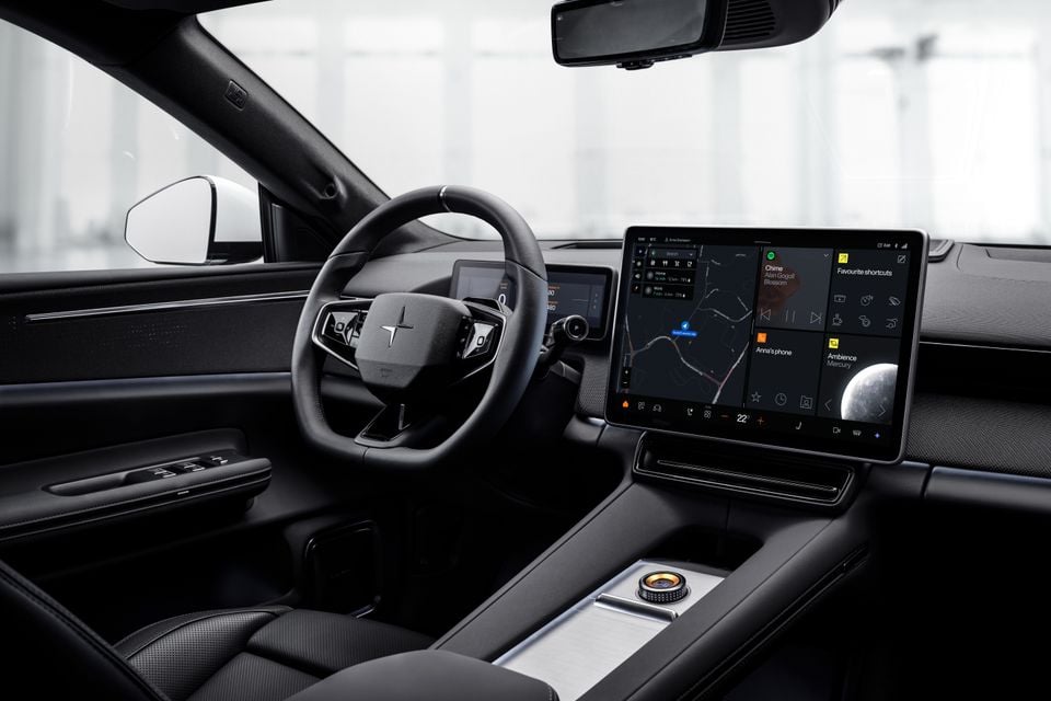 Polestar 4 interior showing the steering wheel, large central touchscreen infotainment system with navigation and media controls, and minimalist dashboard