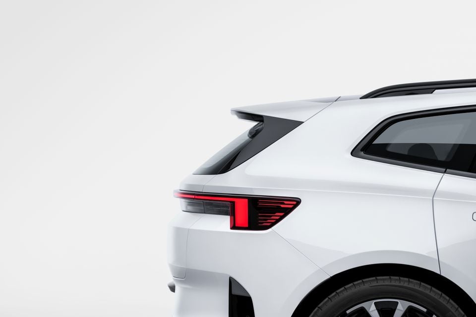 Close-up of the rear corner of a white 2027 Polestar 4 SUV, showing the tail light and roofline against a white studio background.